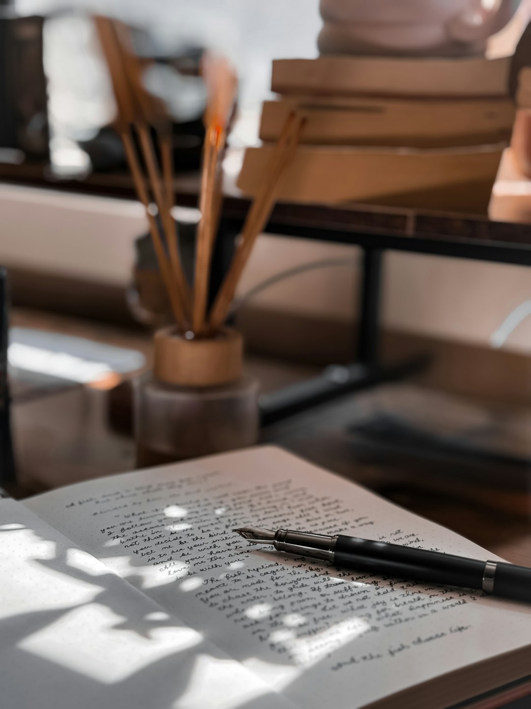 Handwritten journal and fountain pen on a wooden desk.
