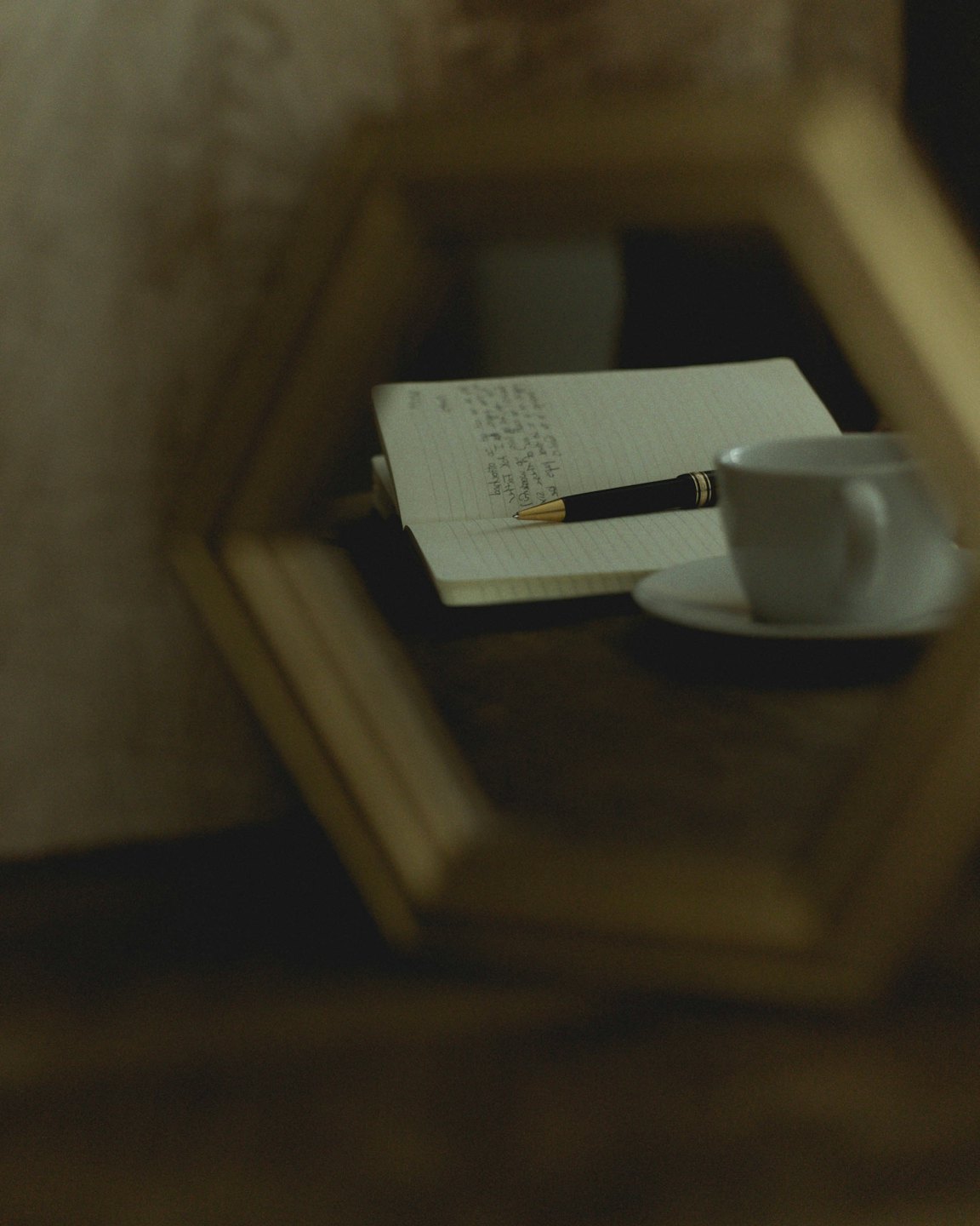 A black and gold fountain pen rests on an open notebook.